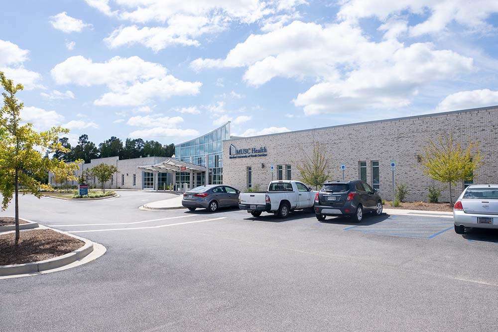 Parking lot with several vehicles and a one-story building.