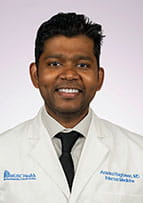 Headshot of a doctor wearing a white coat and a necktie.