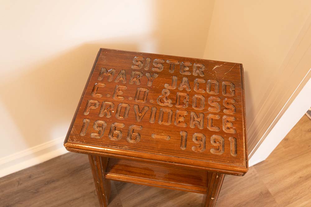 Brown wooden table with the words “Sister Mary Jacob, CEO and boss, Providence, 1966-1991" carved on top.