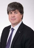 Headshot of a man in a suit and tie.