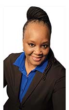 Woman with her hair pulled back smiles. She is wearing a blue shirt and a dark blazer.