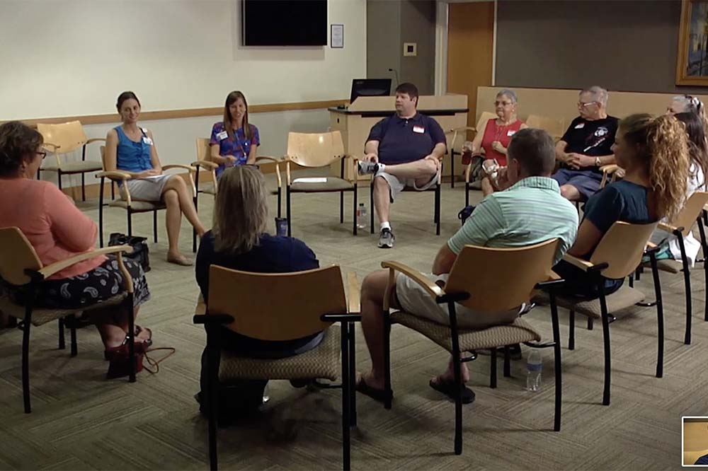 Group of people in chairs seated in a circle