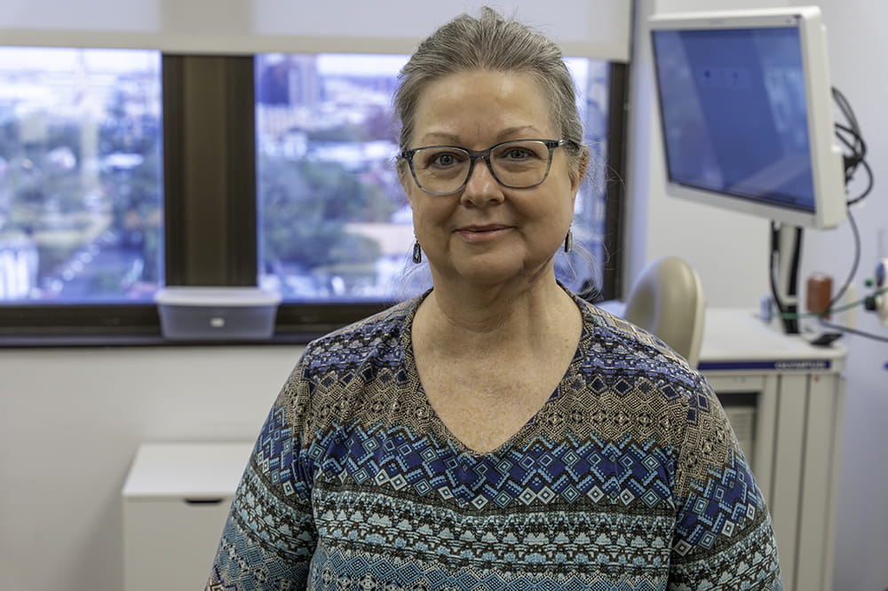 portrait of a woman gazing at the camera in a doctor's exam room