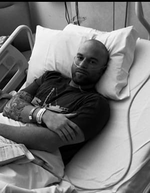 black and white photo of a younger man in a hospital bed