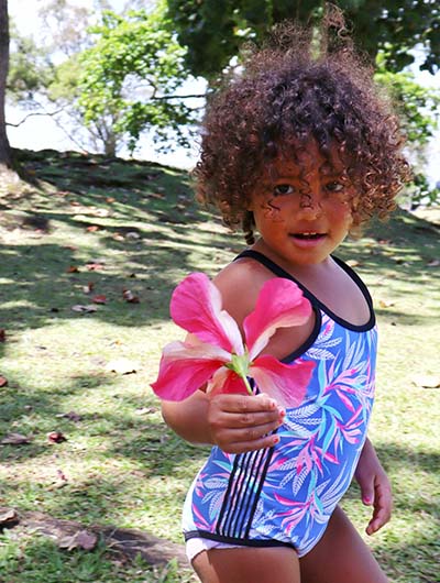 Child in a swimsuit holding a toy.
