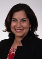 Headshot of dark-haired woman in business clothing.