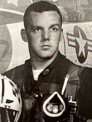 black and white portrait of a fighter pilot in front of his plane