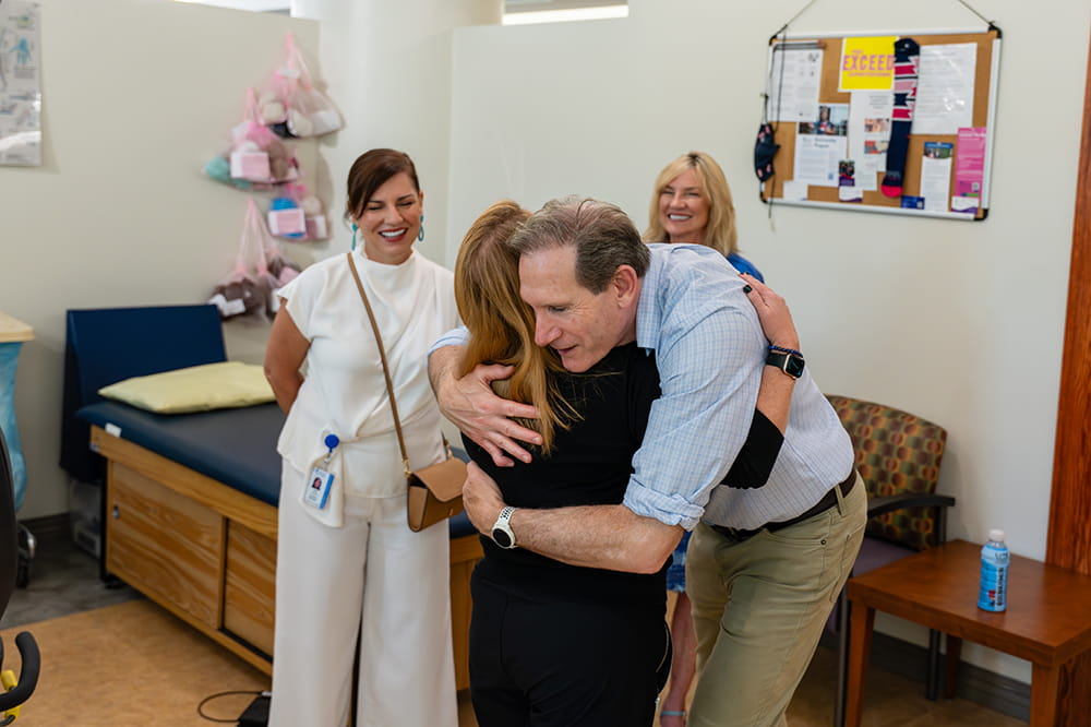 a man leans down to hug a woman in a PT space